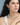 Woman wearing a beaded necklace featuring a balanced half-and-half arrangement of light green and white moonstone beads, paired with a matching drop earring on a silver hoop; styled with a white tank top against a soft blue background.