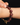 Close-up image of a hand wearing a bracelet made of round strawberry quartz beads in a deep red-plum hue, showing the natural shimmer and tiny inclusions within each stone. The bracelet features tiny faceted 14k gold spacer beads and a central 14k gold rondelle set with nine natural diamonds. A 14k gold toggle clasp is partially visible at the wrist, with the jewelry set against a dark background for contrast.