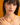 Close-up portrait of a model wearing the Aura Citrine Necklace, consisting of two delicate strands of shimmering faceted citrine beads interspersed with tiny 14k gold spacers. A freshwater pearl with an organic, teardrop shape gracefully hangs from a diamond-encrusted 14k gold bail at the necklace's center. The necklace, paired harmoniously with matching pearl earrings, shines beautifully against a soft amber-toned background.