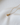 Delicate yellow gold necklace featuring a warm golden topaz pendant on luminous white fabric.
