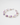 Close-up angled view of The Moonlet Bracelet in Dusk Violet resting on a glossy white surface. The bracelet features a soft interplay of organic freshwater pearls and smooth purple fluorite beads, spaced by tiny silver accents.
