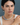 Close-up of a woman wearing the Meridian Necklace and matching earring, showcasing the elegant contrast of moonstone and pale lavender blue lace agate beads against a white tank top and blue-gray background.